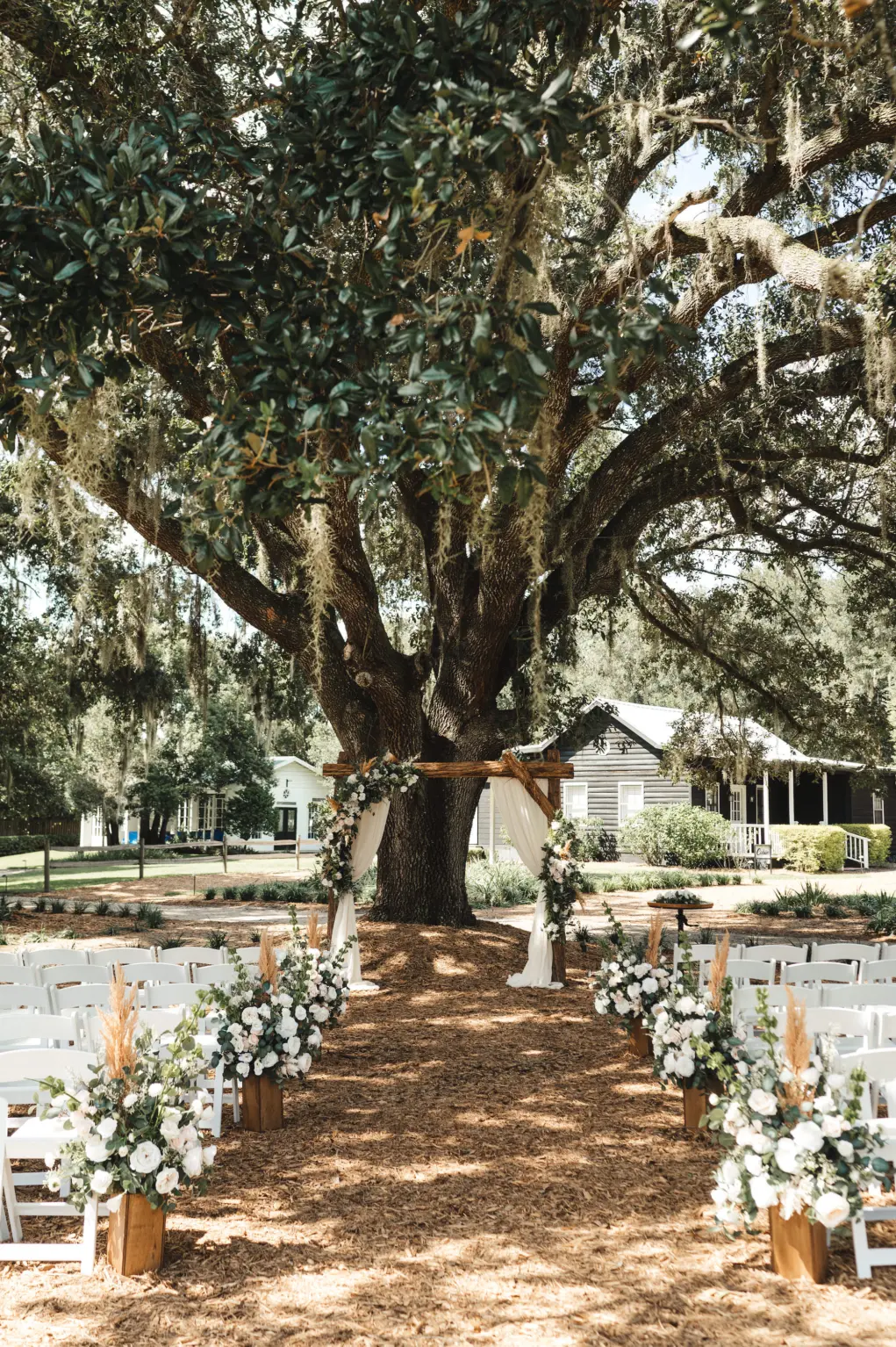 Oak Tree Wedding Ceremony Inspiration | White and Blush Roses with Pampas Grass Aisle Floral Arrangement Ideas | Tampa Bay Florist Monarch Events and Design | Venue Cross Creek Ranch