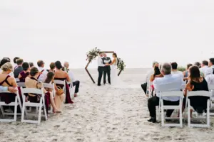 Bride and Groom Vow Exchange | Wooden Hexagon Beach Wedding Ceremony Backdrop with Burgundy Scabiosa, Roses, White Hydrangeas, and Greenery Fall Flower Arrangement Ideas | St Pete Planner Elope Tampa Bay