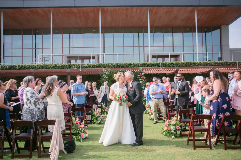 Bride and Groom Just Married Summer Wedding with Brown Folding Chairs and Floral Inspiration | Tampa Florist Monarch Events and Designs | Photographer Carrie Wildes Photography | Venue Streamsong Resort