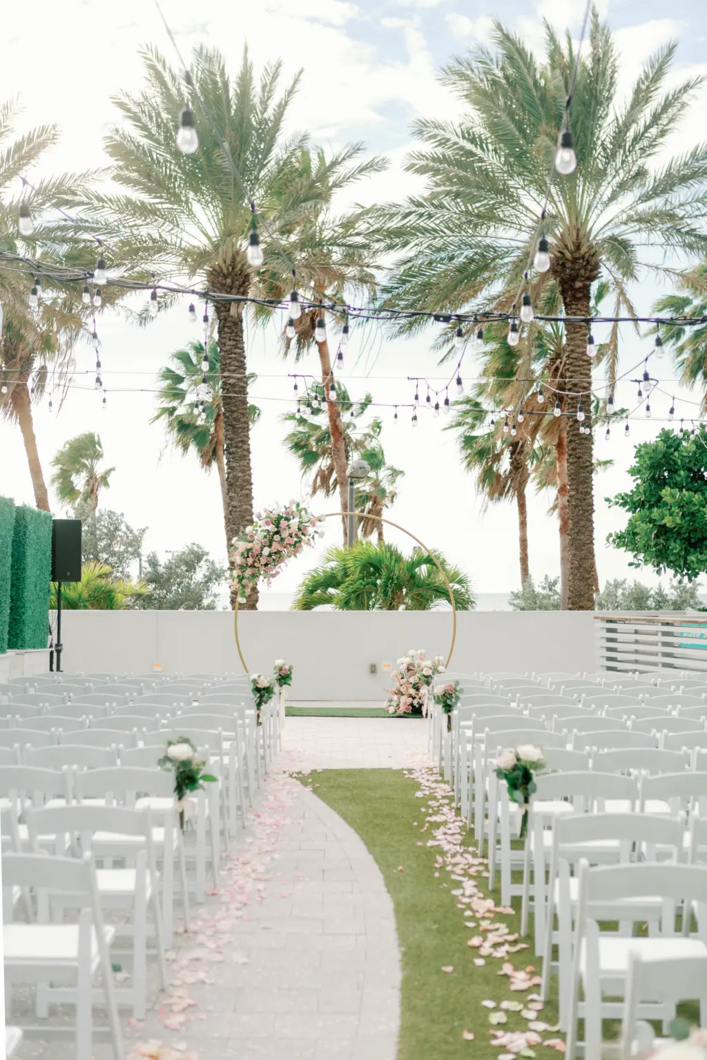 Gold Circle Arch Wedding Ceremony Ideas with Pink Flowers | White Folding Chairs in Outdoor Tropical Wedding | Venue Wyndham Grand Clearwater Beach