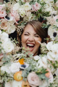 Bride Surrounded by Bouquets Wedding Portrait | Spring Wedding Bouquet with Pink, Orange, and White Roses and Greenery Inspiration