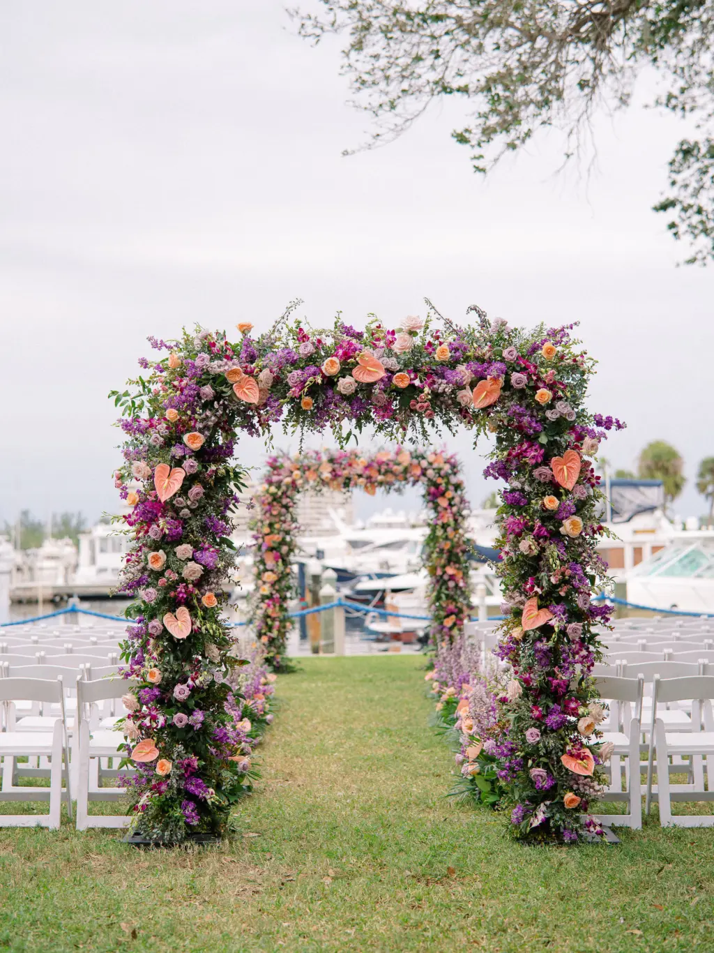 Tropical Floral Aisle Arch Inspiration | Orange Anthurium, Pink Roses, Purple Foxglove Flowers, and Greenery | Waterfront Wedding Ceremony Ideas | Sarasota Florist Botanica Design Studio