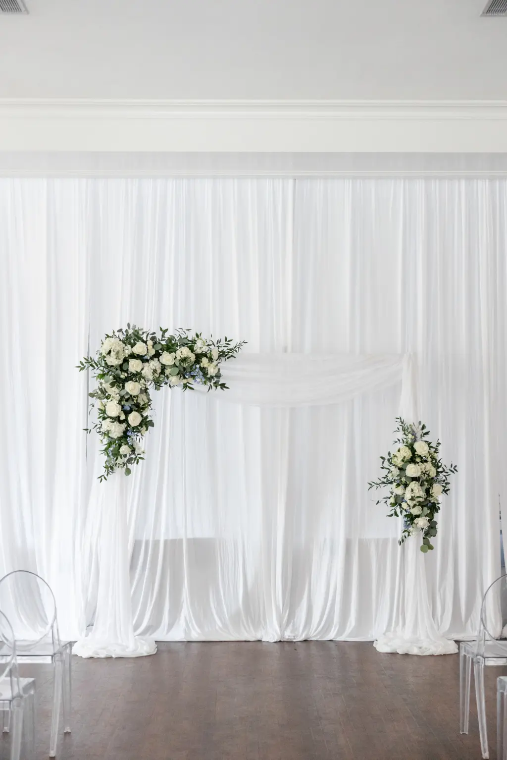 White Drapery and Piping | Asymmetrical Floral Arrangements with White Roses, Blue Flowers, and Greenery Wedding Ceremony Arch Ideas | Tampa Bay Kate Ryan Event Rentals | Florist Monarch Events and Design