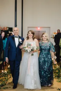 Bride with Father and Mother Walking Down Wedding Aisle