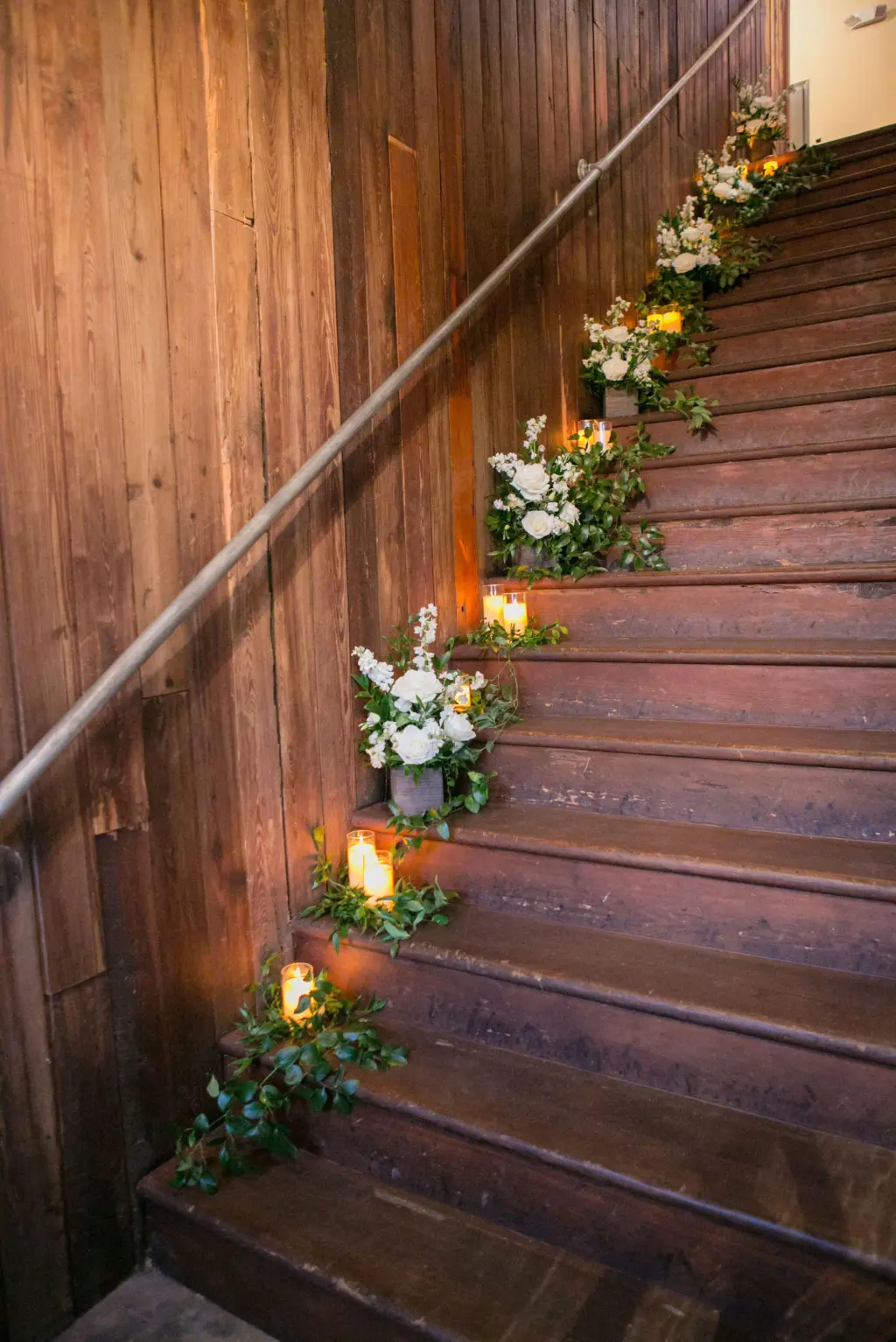 Candlelit Stairs Decor for Wedding Reception | Greenery, White Roses, and Stock Flowers