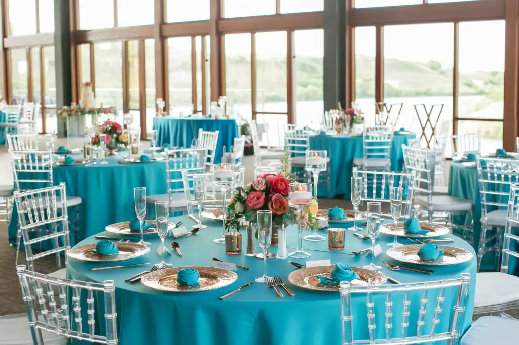 Colorful Turquoise Linen Wedding Reception with Coral Details and Ghost Chiavari Chairs, and Floral Centerpieces | Tampa Florida Rentals A Chair Affair Linens | Florist Monarch Events and Designs