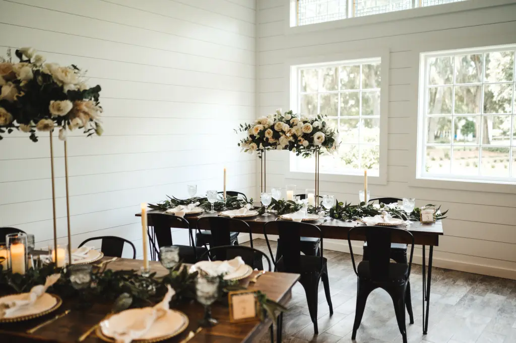 Modern and Rustic Indoor Wedding Reception | Tall Flower Stand Centerpieces with White Roses and Greenery | White and Gold Table Setting Ideas
