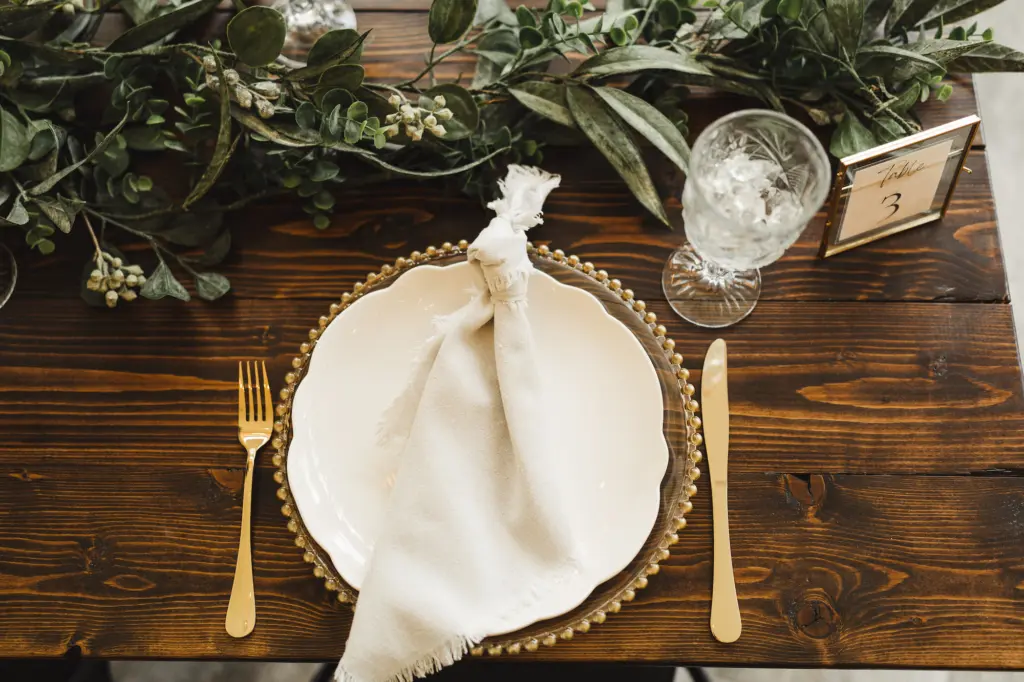 Gold Beaded Chargers with Gold Flatware and White Fringe Napkins