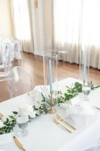 Light Blue Taper Candles with Hurricane Glass tubes | Greenery Garland Centerpiece Ideas | Tampa Florist Monarch Events and Designs | Kate Ryan Event Rentals