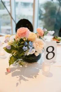Modern Black and White Table Number Card with Pastel Orange and Pink Roses, Greenery, and Blue Flowers for Spring Wedding Reception Decor Ideas