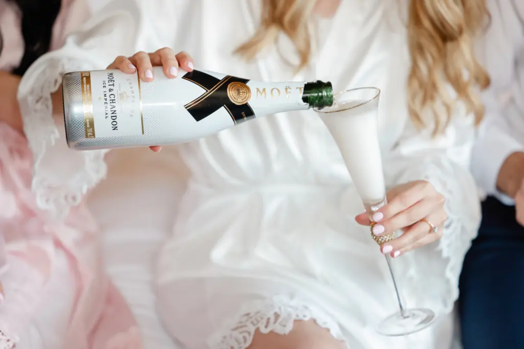 Bride Pouring Champagne in White Silk Robe Bridal Portrait