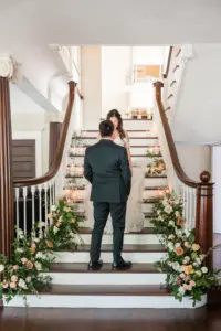 Bride and Groom First Look Wedding Portrait on Staircase with Peach and Cream Florals in Greenery