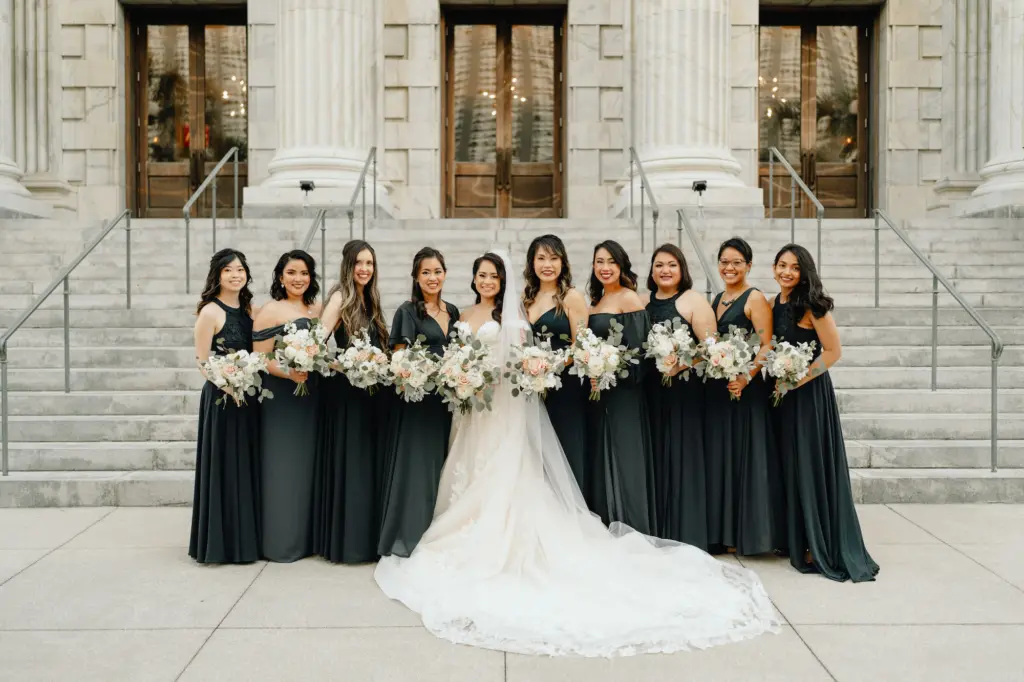 Bride and Bridesmaids Wedding Portrait | Bridesmaids in Floor Length Mix and Match Bridesmaids Dresses Holding White Floral Bouquets with Eucalyptus | Downtown Tampa Wedding Venue Le Meridien