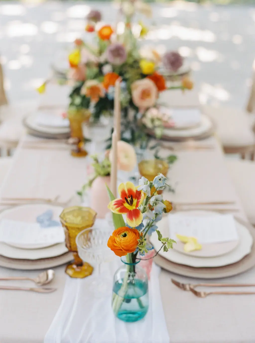 Bud Vase Centerpieces with Orange Ranunculus, Tulips, and Blue Stock Flowers | White Cheesecloth Table Runners | Whimsical Vineyard Wedding Reception Inspiration | Tampa Bay Florist Save The Date Florida