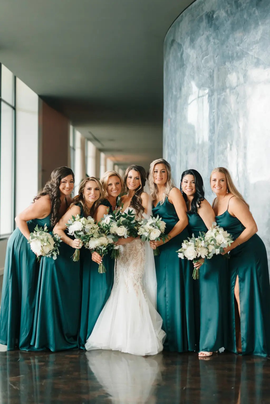 Bride with Bridesmaids in Emerald Floor Length Bridesmaids Dresses and White and Greenery Floral Wedding Bouquet Ideas Portrait