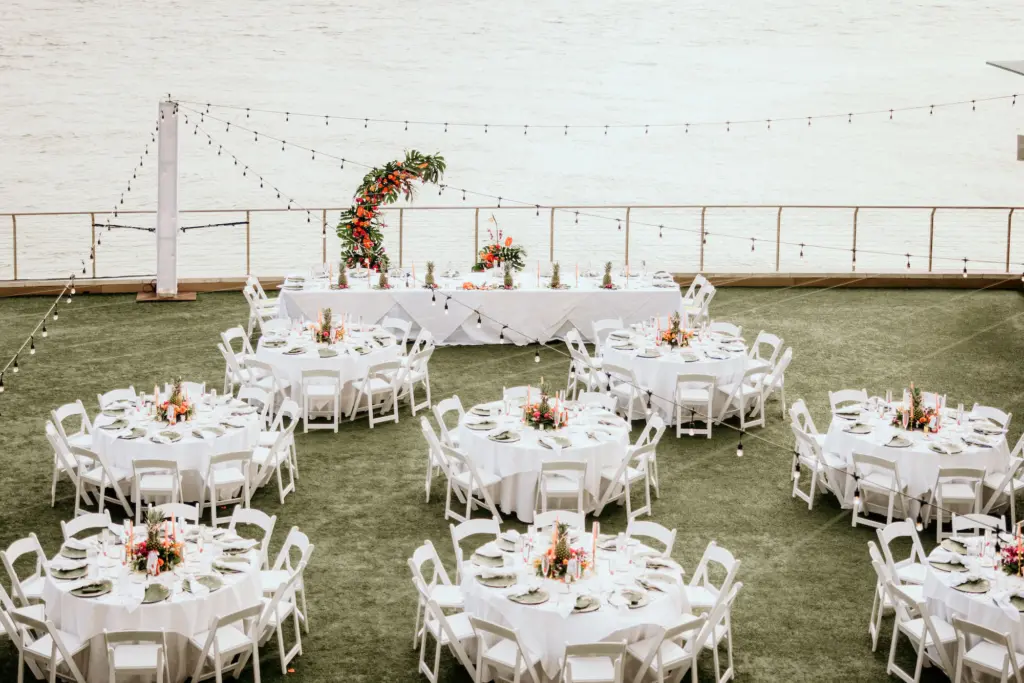 Round Tables with White Linen and White Folding Chair Tropical Outdoor Wedding Reception Inspiration | Clearwater Beach Florist Save the Date Florida | Planner Elegant Affairs by Design | Venue Opal Sands