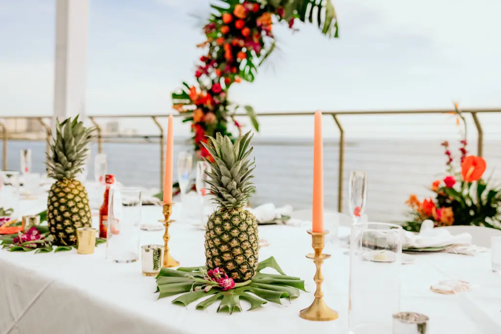 Tropical Wedding Inspiration with Pineapple and Monstera Leaf Centerpieces | Coral Tapered Candles with Gold Accents | Clearwater Beach Florist Save the Date Florida