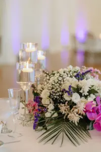 Tropical Wedding Reception Centerpiece with Purple Orchids and White Floral Detailing and Floating Candles in Asian Fusion Wedding Décor