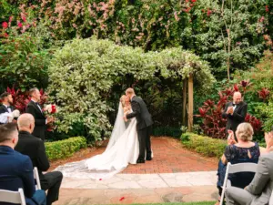 Bride and Groom First Kiss for Christmas Inspired Garden Wedding Ceremony Inspiration | Downtown St. Petersburg Florida Event Venue Sunken Gardens | Planner Wilder Mind Events