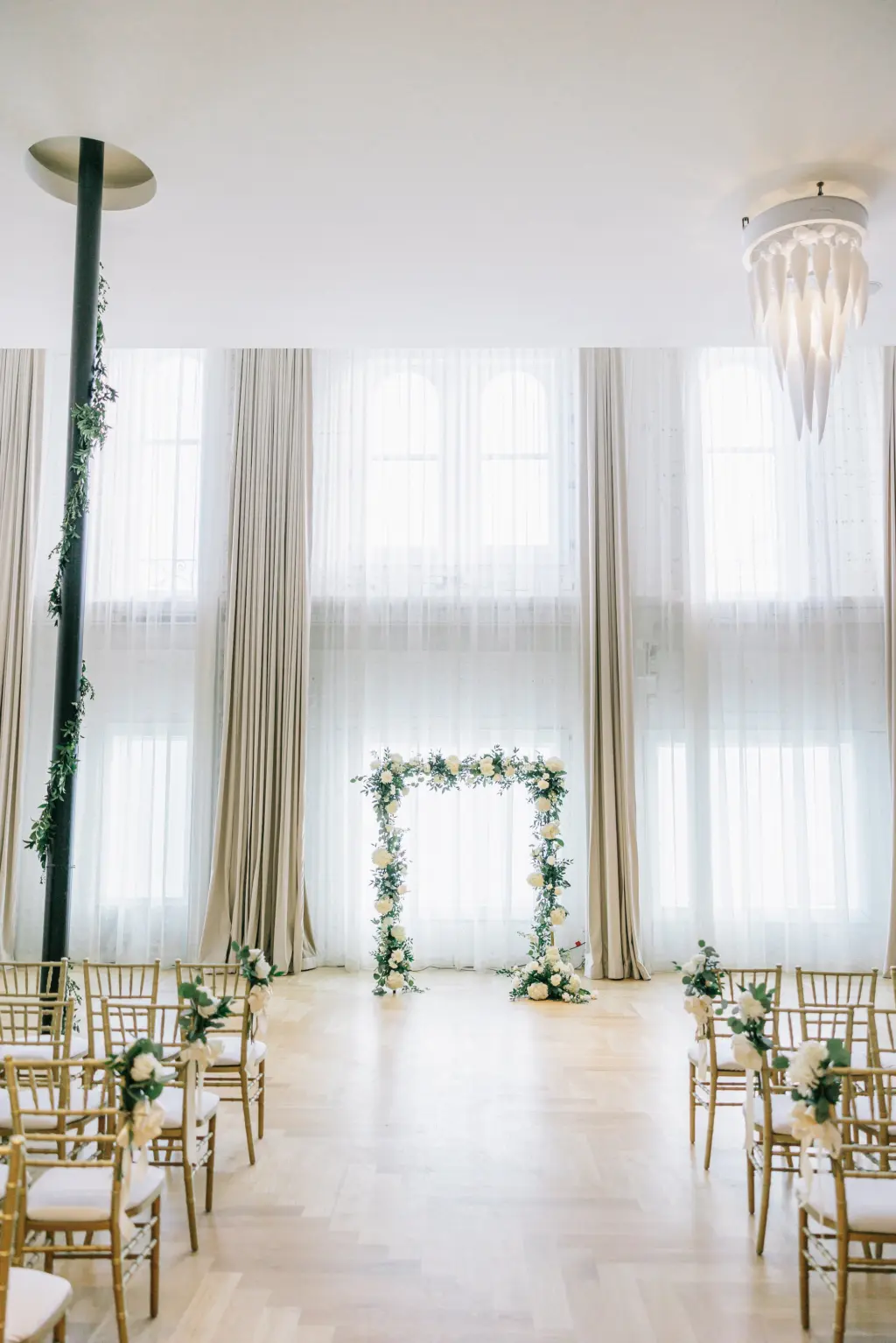 Gold Chiavari Ceremony Chairs with White Floral and Greenery Detail Floral Arch in Romantic Industrial Wedding Ceremony | Tampa Wedding Rentals Kate Ryan Event Rentals | Venue Hotel Haya