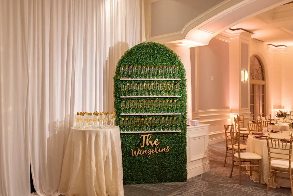 Elegant Champagne Boxwood Greenery Wall Welcome Drink Display with Acrylic Place Card Tags for Fall Wedding Reception Decor Inspiration