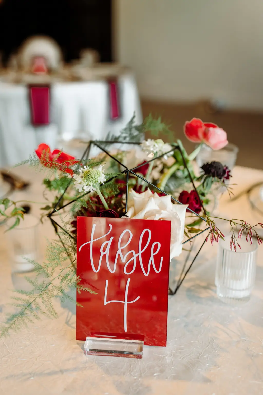 Hand-lettered Table Number Sign Ideas | Black Geometric Centerpiece with Pink Roses, Red Carnations, and Protea | Modern Asian Wedding Reception Inspiration