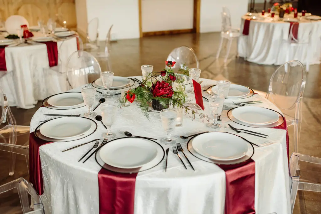 Modern Wedding Reception Ideas with Red Centerpieces and Black Flatware and Glass Chargers | Tampa Bay Kate Ryan Event Rentals