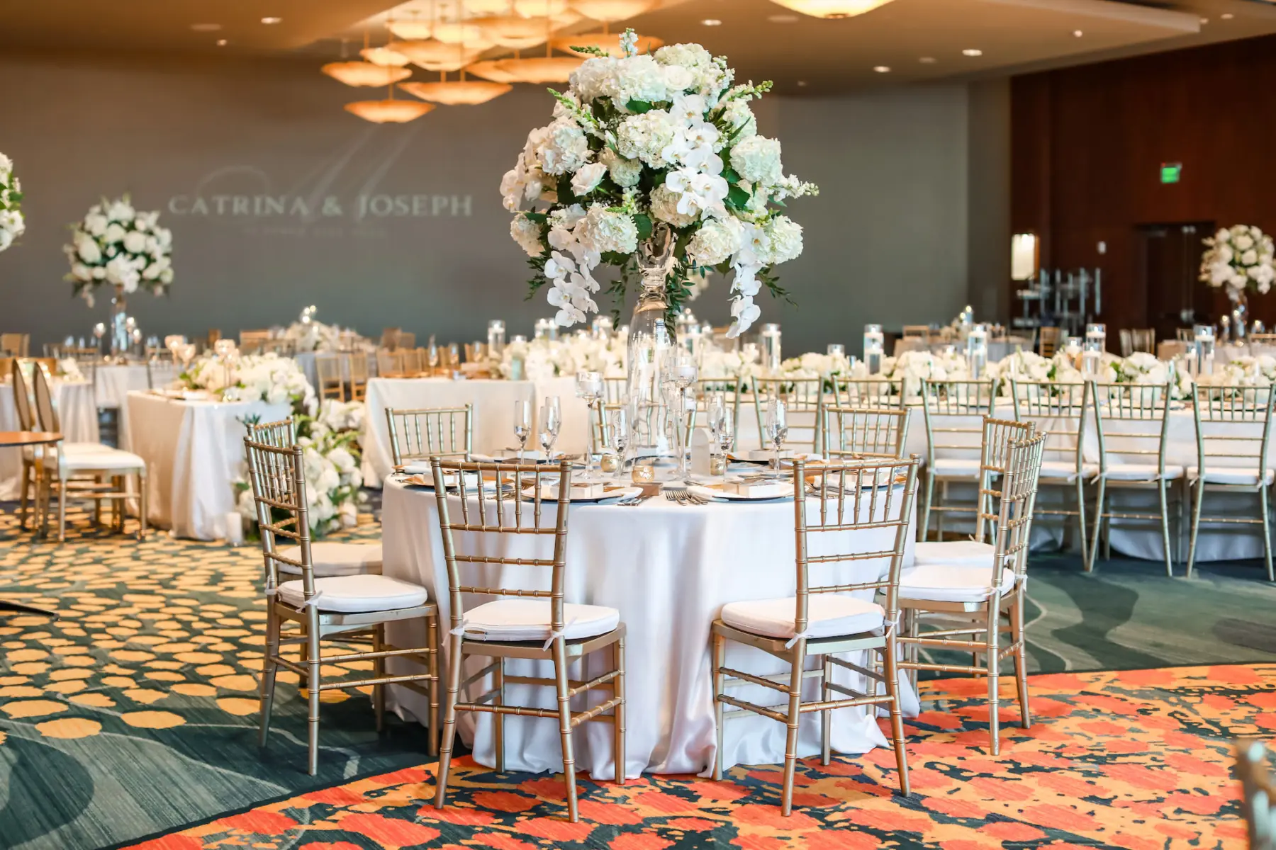 Elegant Monochromatic White and Gold Ballroom Wedding Reception Ideas | White Rose, Hydrangea, Orchid, and Greenery Decor Inspiration | Gold Chiavari Chairs | Tampa Bay Outside Of The Box Rentals | Clearwater Event Planner Breezin Weddings