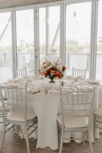 Boho Wedding Reception Inspiration | Silver Chiavari Chairs with White Linen | Orange, Pink, and White Roses with Greenery Centerpiece Ideas