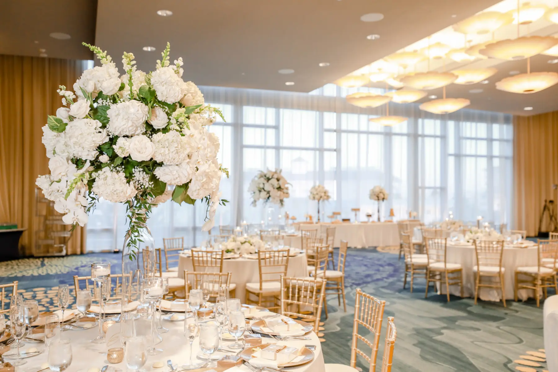 Elegant Monochromatic White and Gold Ballroom Wedding Reception Ideas | White Rose, Hydrangea, and Floating Candle Centerpiece Decor Inspiration | Gold Chiavari Chairs | Tampa Bay Outside Of The Box Rentals | Clearwater Kate Ryan Event Rentals