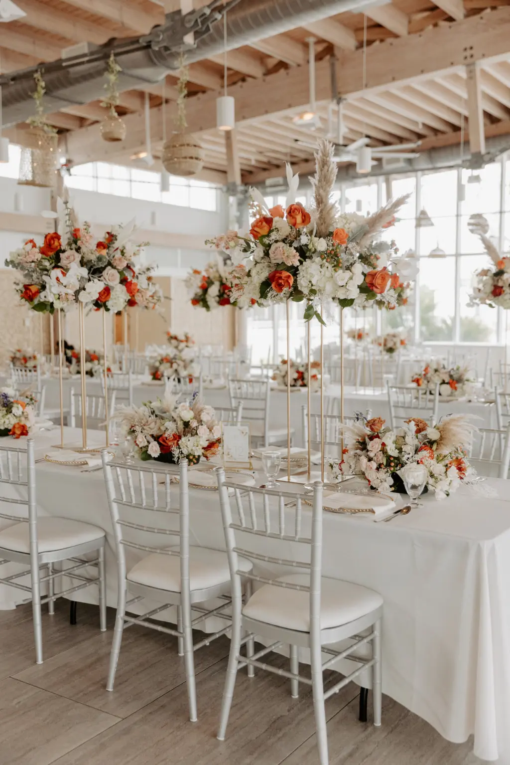 Tall Flower Stand Wedding Reception Centerpiece Ideas with Pampas Grass, Orange, Pink, and White Roses, Carnations, Hydrangeas, and Dried Florals