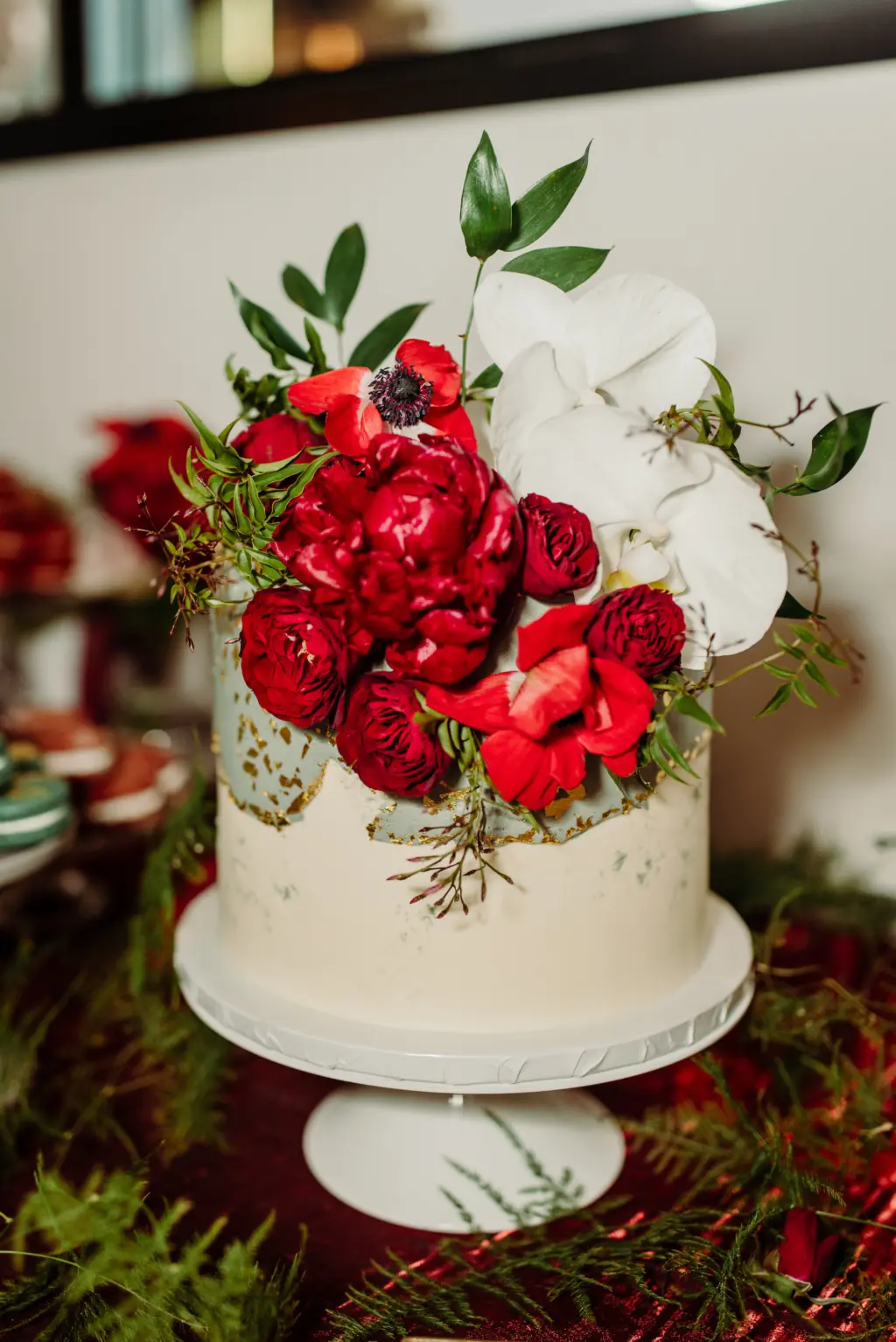 Modern Single-tiered Round White and Green Wedding Cake Ideas with Gold Flakes, Red Carnations and White Orchids