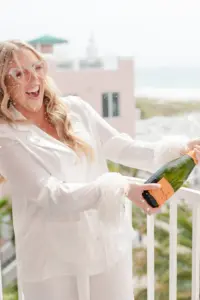 Bride Celebrating with Champagne on the Balcony Before Wedding