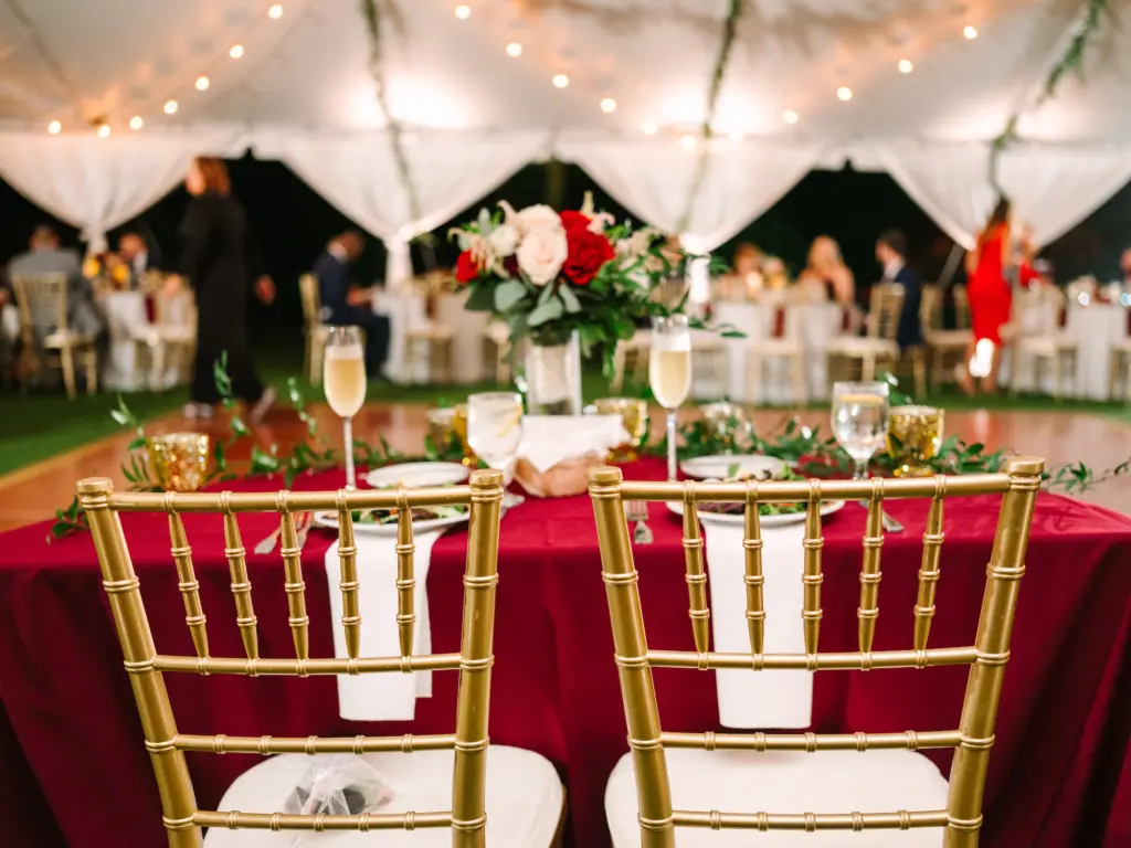 Red and White Christmas Wedding Reception Sweetheart Table Inspiration with Gold Chiavari Chairs | Caterer Amici's Catered Cuisine