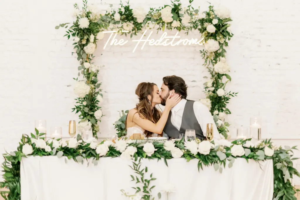 Bride and Groom at Romantic White Gold and Greenery Sweetheart Table with White Linens Wedding Inspiration Portrait | Tampa Rentals Kate Ryan Event Rentals | Planner Eventfull Weddings | Venue Hotel Haya