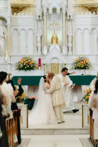 Bride and Groom First Kiss Wedding Portrait in Catholic Church Wedding Ceremony | Tampa Church Sacred Heart Catholic Church | Tampa Wedding Photographer J&S Media