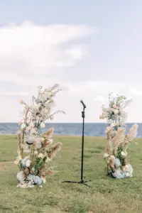 Tall Boho Coastal Wedding Ceremony Altar Flower Arrangement Decor Inspiration with Pampas Grass, Baby's Breath, Blue Hydrangeas, and White Roses