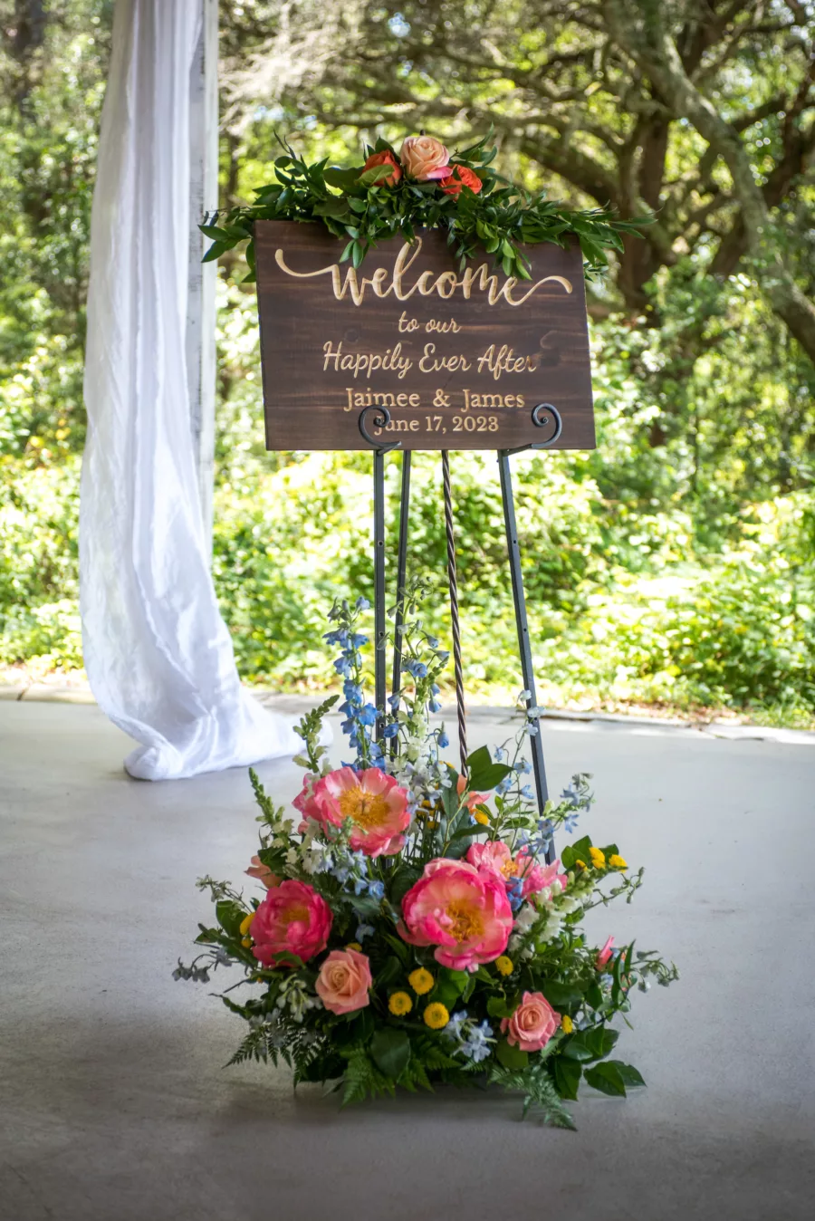 Wooden Welcome Wedding Sign Decor with Vibrant Pink Peony, Blue Stock Flowers, and Greenery Floral Arrangement Ideas