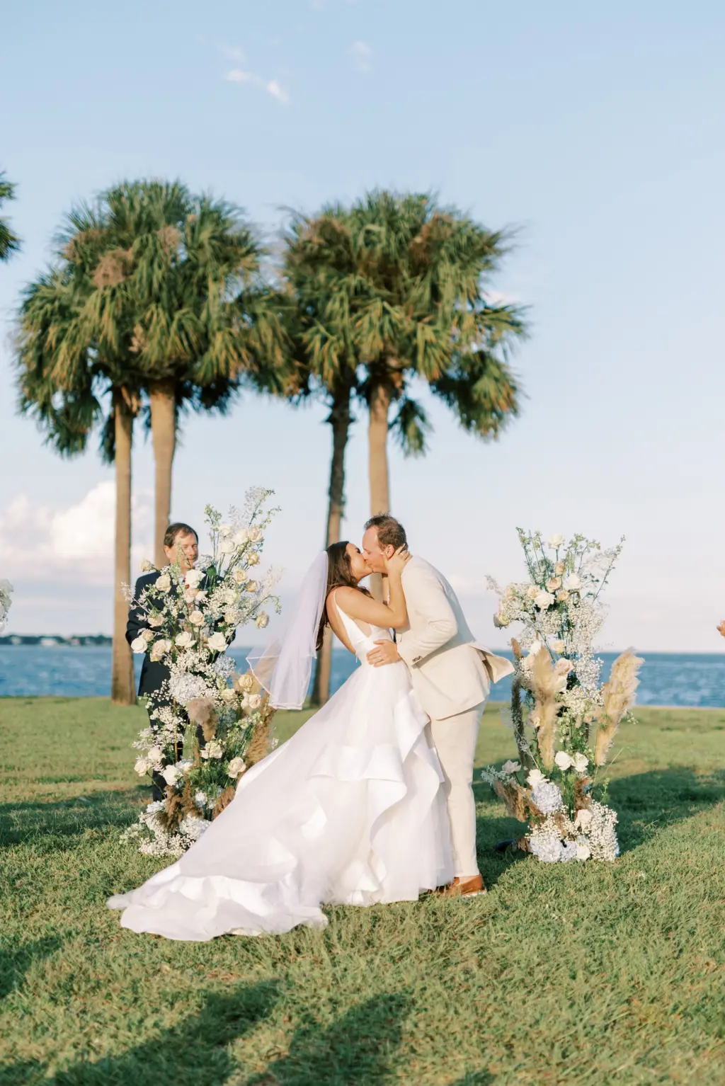 Outdoor Waterfront Florida Wedding Ceremony | Tall Boho Altar Flower Arrangement Decor Inspiration with Pampas Grass, Baby's Breath, Blue Hydrangeas, and White Roses