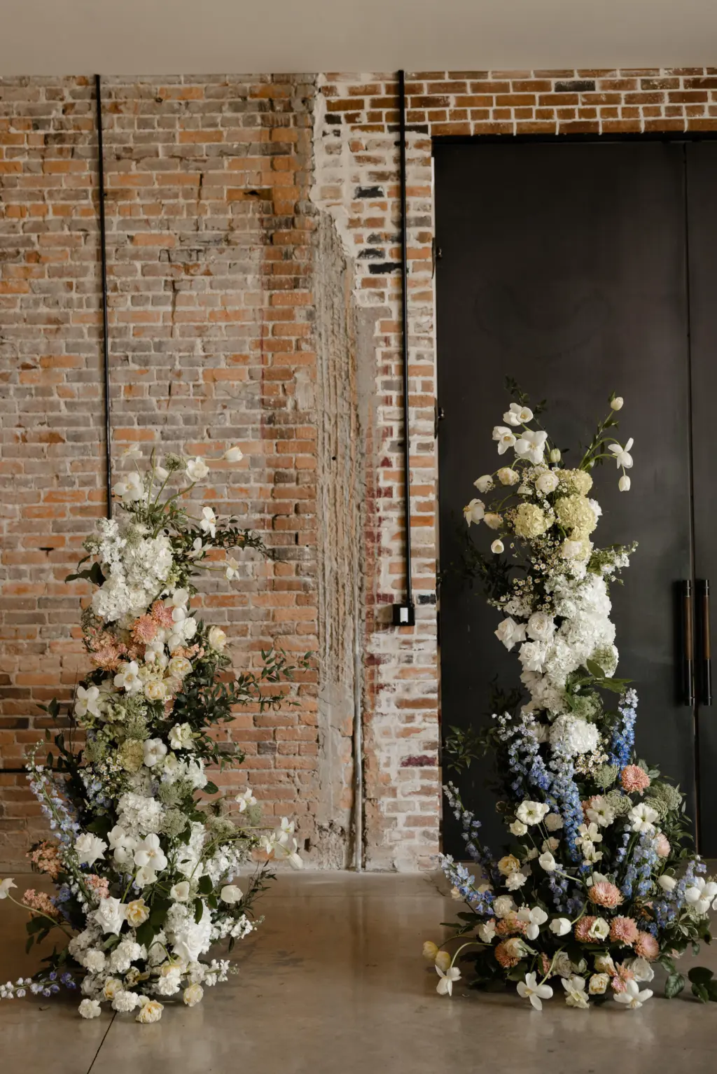 Spring Asymmetrical Wedding Ceremony Flower Arch Ideas with Blue Stock Flowers, Yellow Hydrangeas, Pink Chrysanthemums, and Greenery