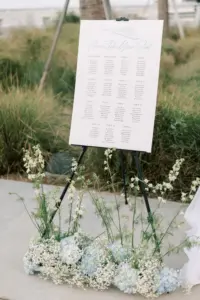 Please Take Your Seat Light Blue and White Wedding Reception Seating Chart Inspiration with Baby's Breath, Blue Hydrangeas, and White Wildflowers