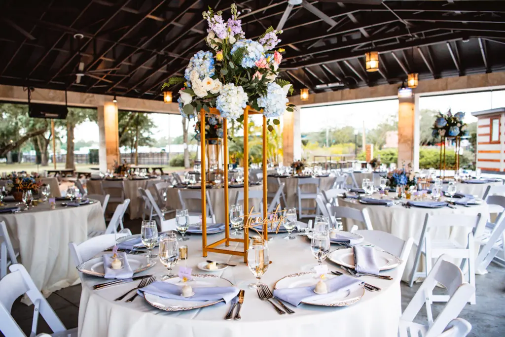 Tall Gold Stand with Blue Hydrangeas, Greenery, Roses, and Purple Stock Flowers | Bridgerton Inspired English Wedding Ceremony Decor Ideas | Tampa Bay Planner B Eventful | Outside the Box Rentals
