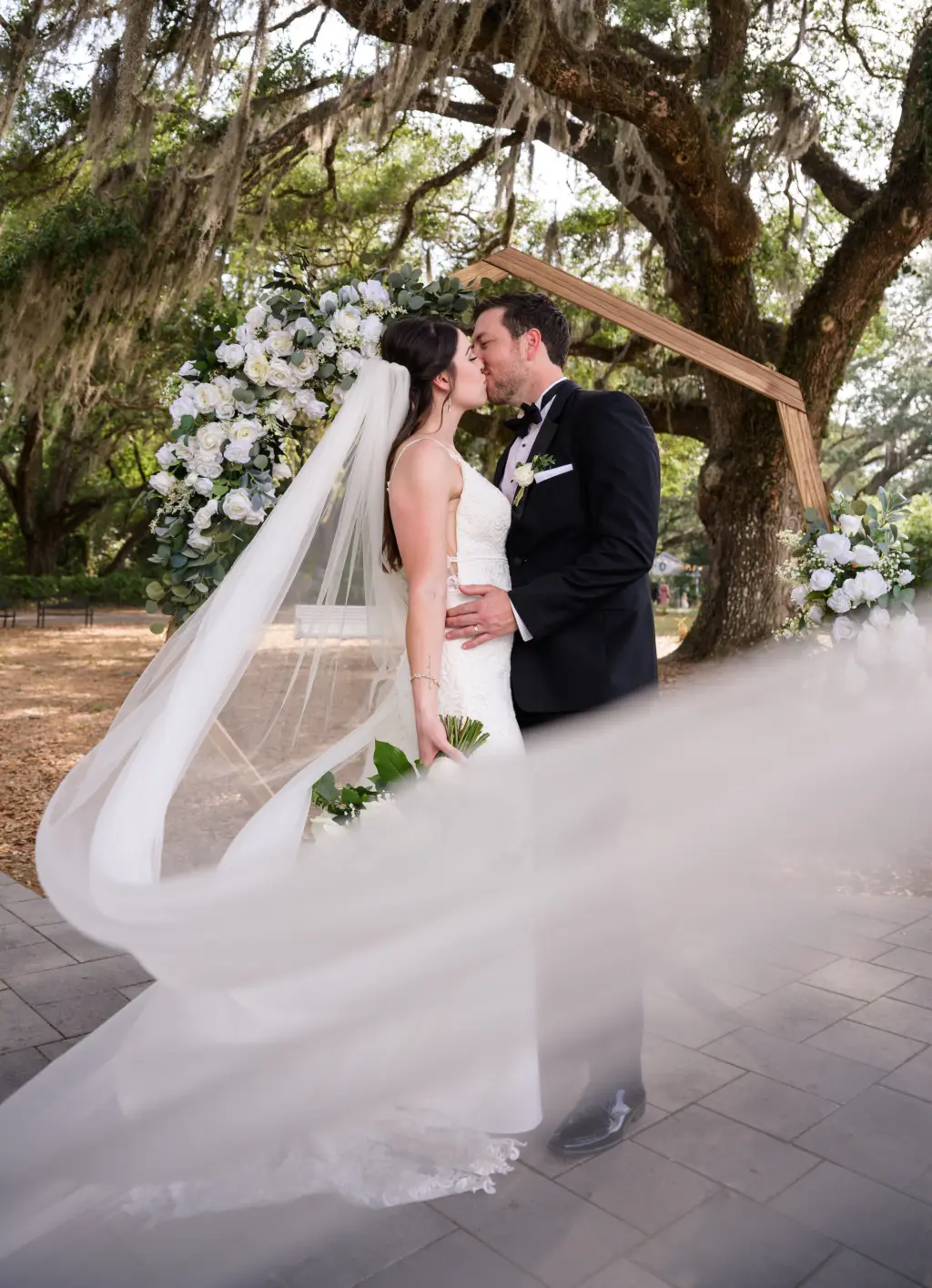 Bride and Groom First Kiss Wedding Portrait | Wedding Geometric Wooden Ceremony Arch | Tampa Bay Event Venue Legacy Lane Weddings