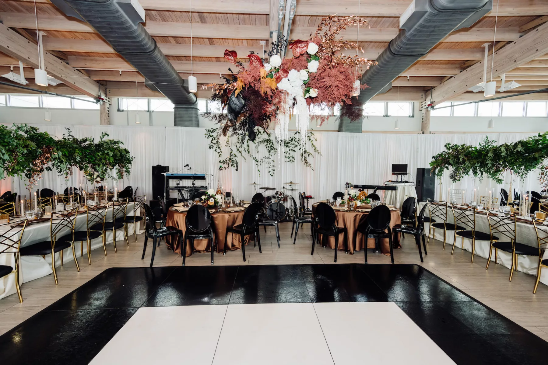 Modern Black and Bronze Wedding Reception Decor Inspiration | Black and White Dance Floor Ideas | Whimsical Fall Floral Chandelier with White Roses, Orange Leaves, Anthurium, and Orange Wisteria Decor | Tampa Bay Rentals A Chair Affair | Venue Tampa River Center
