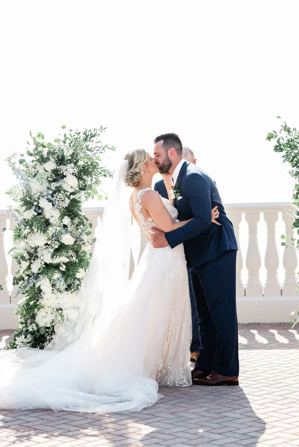 Bride and Groom Kiss Portrait | White Roses, Blue Delphinium, and Greenery Wedding Ceremony Arch Decor Inspiration | Tampa Bay Photographer Lifelong Photography Studio | Event Venue Hyatt Clearwater Beach | Planner Coastal Coordinating