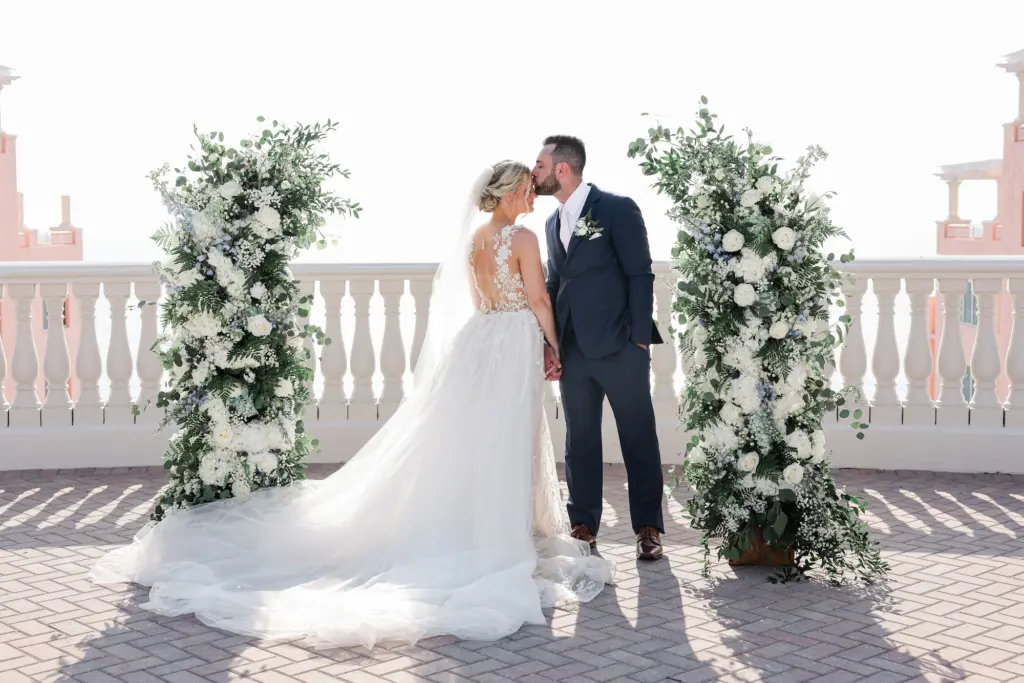 Bride and Groom Just Married Portrait | White Roses, Blue Delphinium, and Greenery Wedding Ceremony Arch Decor Inspiration | Tampa Bay Photographer Lifelong Photography Studio | Event Venue Hyatt Clearwater Beach | Planner Coastal Coordinating