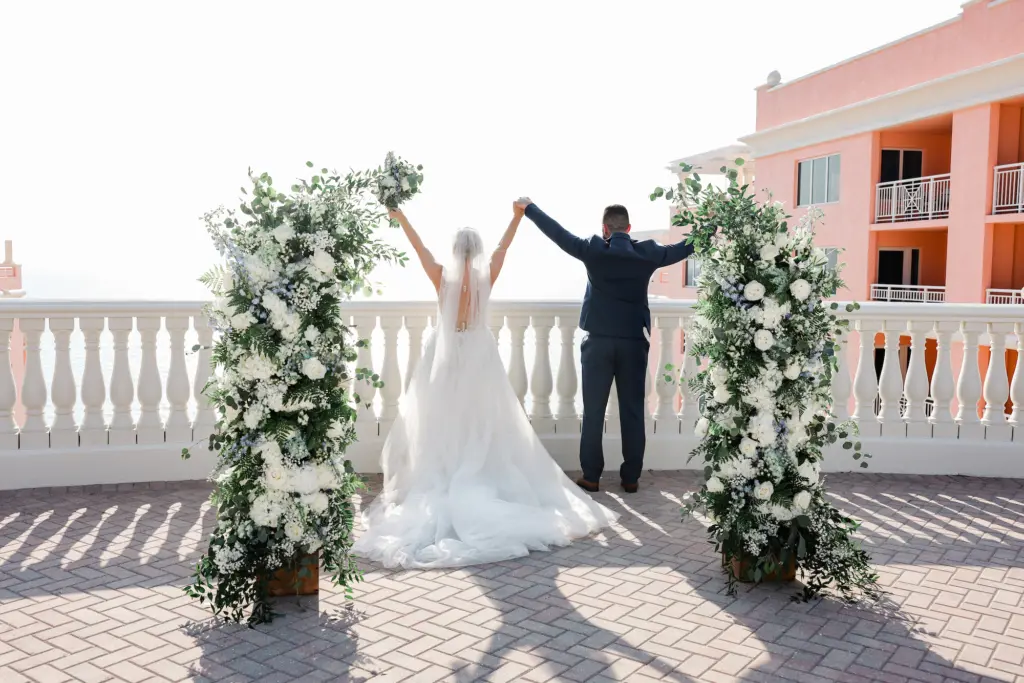 Bride and Groom Just Married Portrait | White Roses, Blue Delphinium, and Greenery Wedding Ceremony Arch Decor Inspiration | Tampa Bay Event Venue Hyatt Regency Clearwater Beach