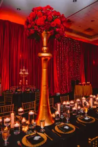 1920s Great Gatsby Gold Vintage Tall Centerpiece with Red Roses and Floating Candles Tablescape Wedding Reception Inspiration | Gold Chiavari Chairs and Chargers from Tampa Event Rentals A Chair Affair