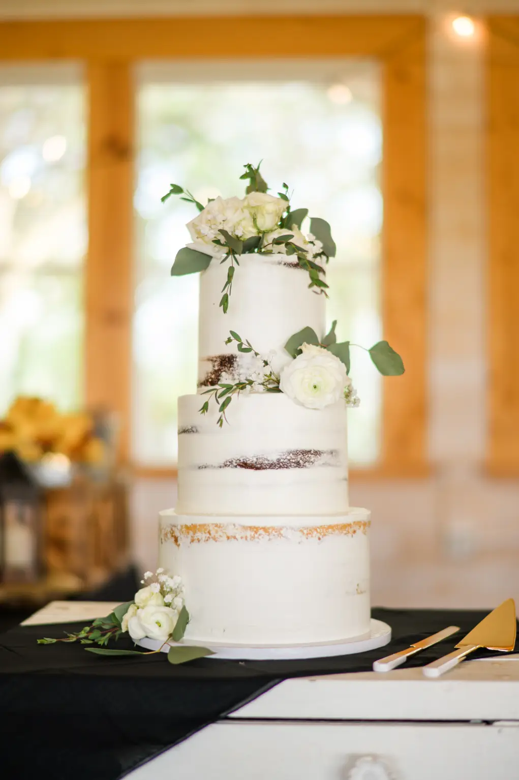 Rustic Round White Three-Tiered Semi Naked Wedding Cake with White Flowers and Greenery Accents Inspiration