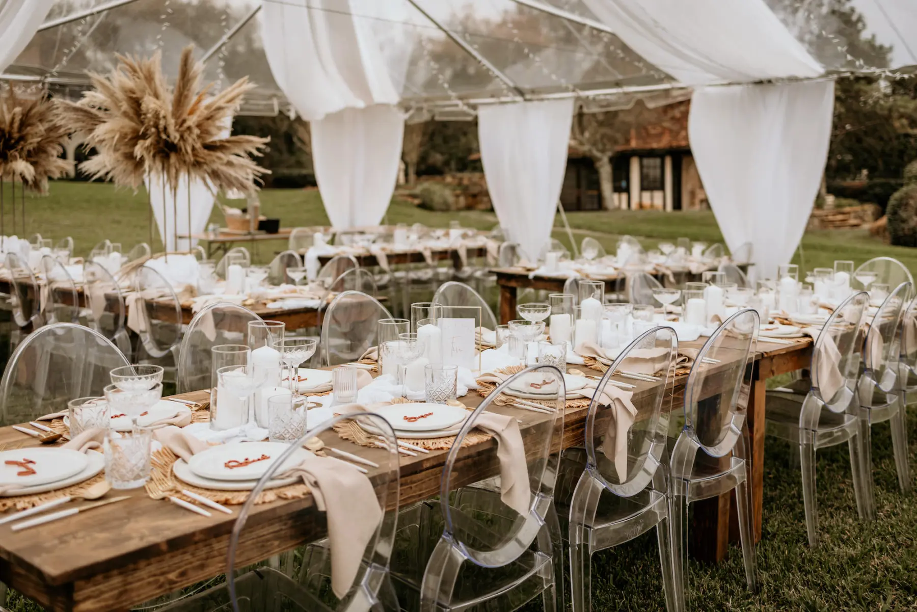 Clear Tented Boho Wedding Reception with Long Feasting Tables and Ghost Chairs Decor Inspiration